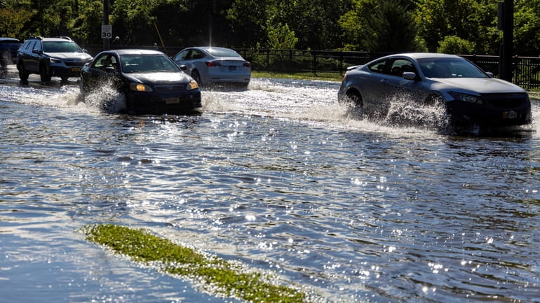 Cars navigate a flooded Searingtown Rd. on Thursday Sept. 2,...