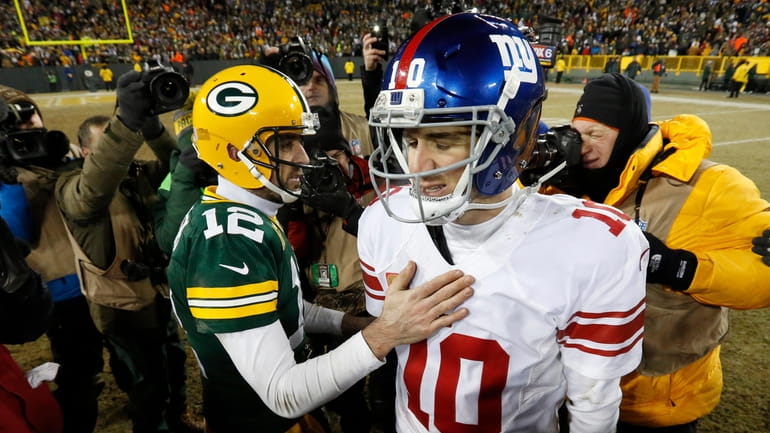 Packers quarterback Aaron Rodgers and Giants quarterback Eli Manning greet each other...