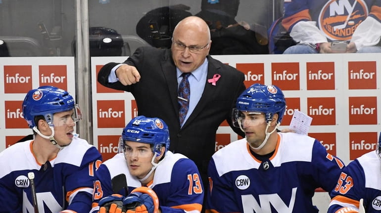 New York Islanders head coach Barry Trotz talks to his...