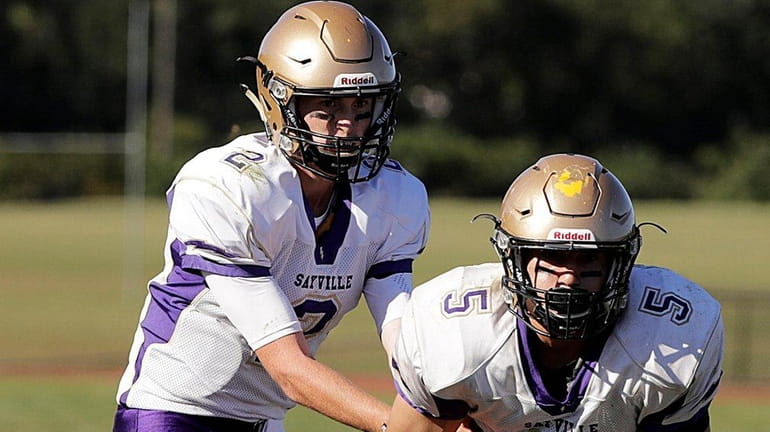 Sayville quarterback Jacob Cheshire hands off to running back Nate...
