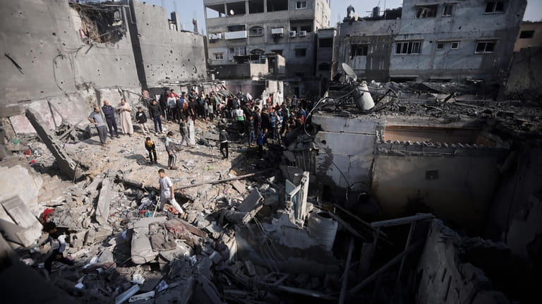Palestinians look at destruction after the Israeli bombing In Khan...