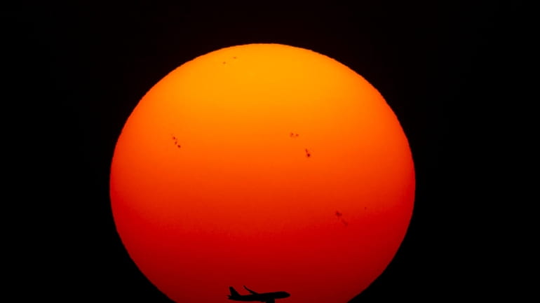 A commercial aircraft approaches the runway as the sun sets...