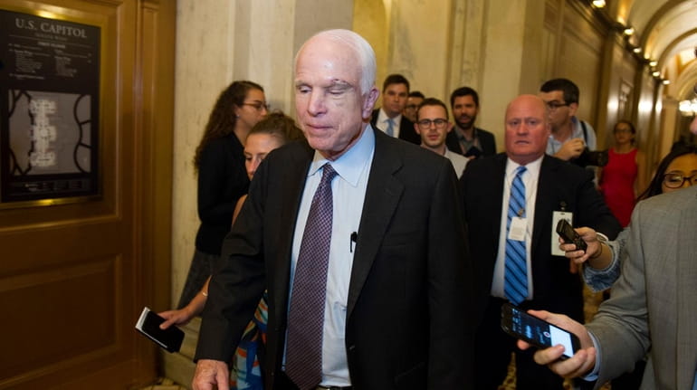 Sen. John McCain (R-Ariz.) is pursued by reporters after casting...