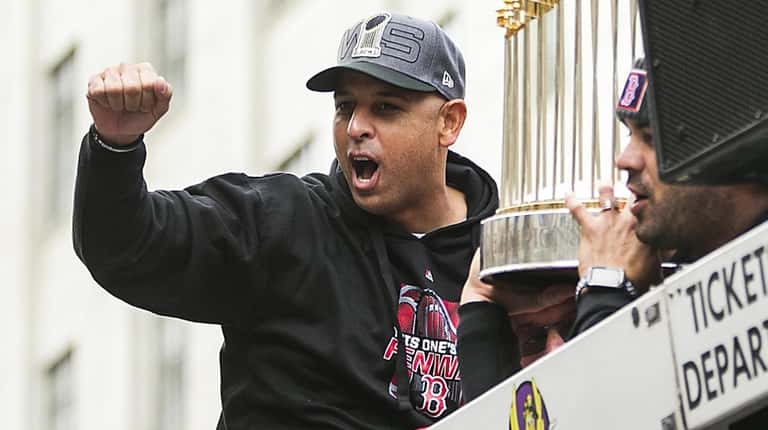 Red Sox manager Alex Cora acknowledges fans during the team's...
