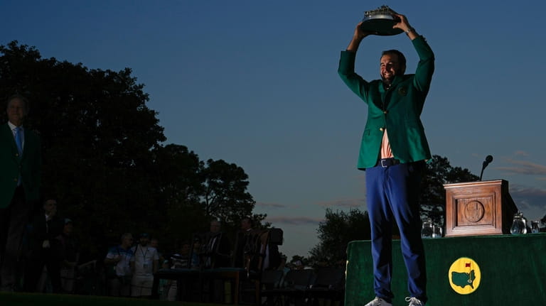 Scottie Scheffler holds the trophy after winning the Masters golf...