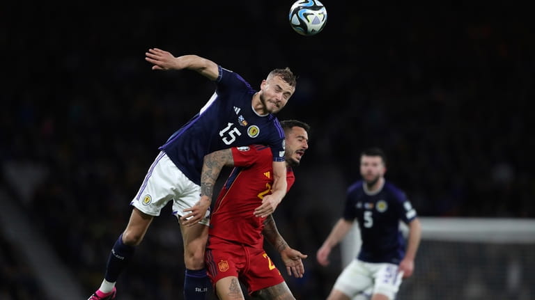Scotland's Ryan Porteous, top, challenges for the ball with Spain's...