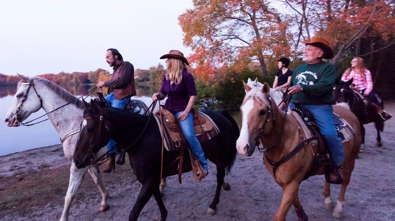 Horseback riders from Babylon Riding Center, take a ride through the...