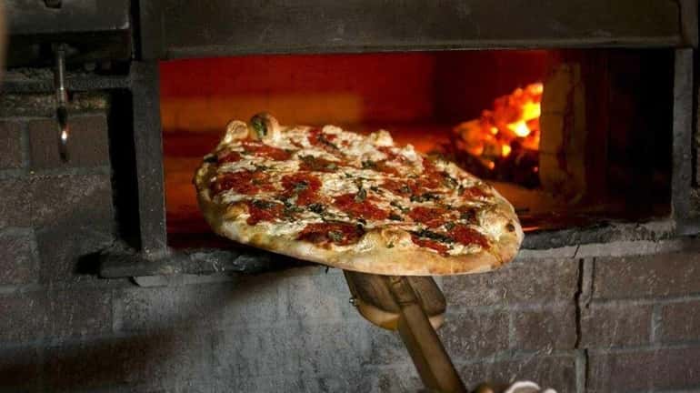 Pizza is baked in a coal-fueled oven at Salvatore's in...