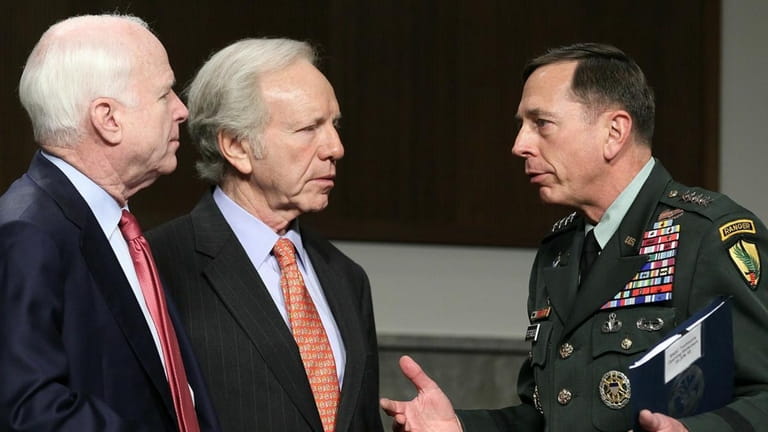 Army Gen. David Petraeus talks with Sen. John McCain (R-Ariz.),...