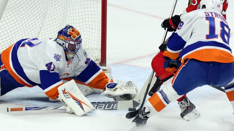 New York Islanders goalie Jaroslav Halak maks a stick save...