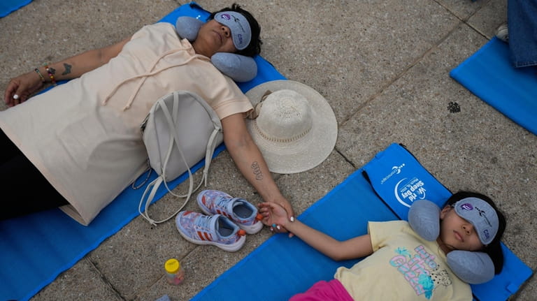 Equipped with mats, sleeping masks and travel pillows, a child...