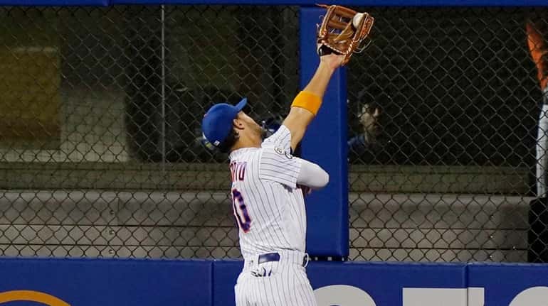 The Mets' Michael Conforto catches a fly ball by the...