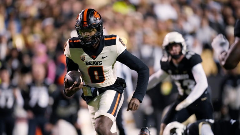 Oregon State quarterback Aidan Chiles runs with the ball during...