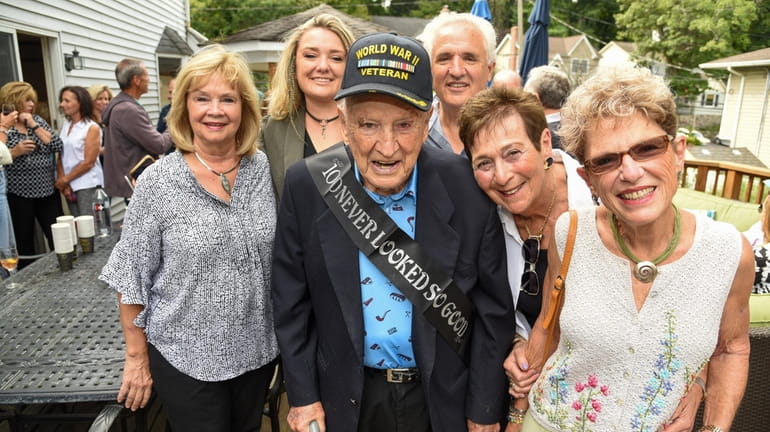 Paul Fazio, center, celebrates his 100th birthday with his family,...
