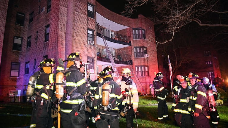 Firefighters at the scene of an apartment building fire in...