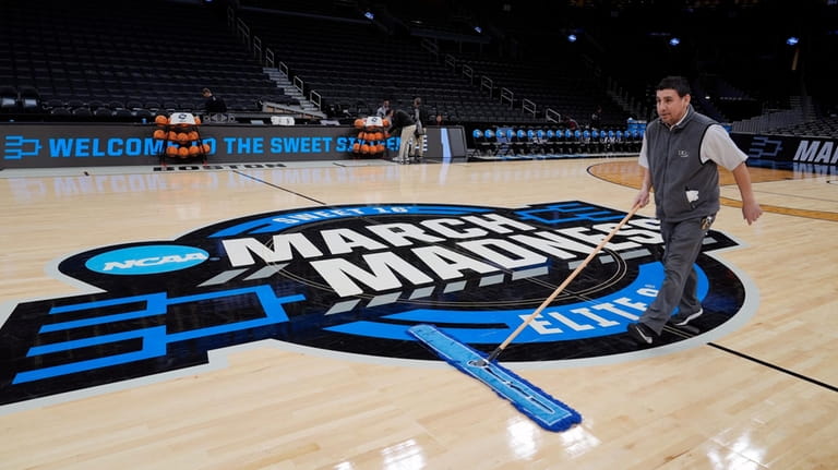 A worker cleans the floor during practices for Sweet Sixteen...