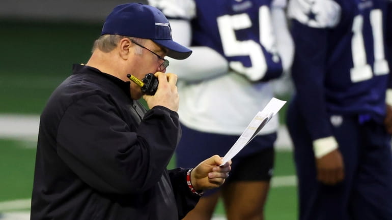 Dallas Cowboys head coach Mike McCarthy talks on a walkie...