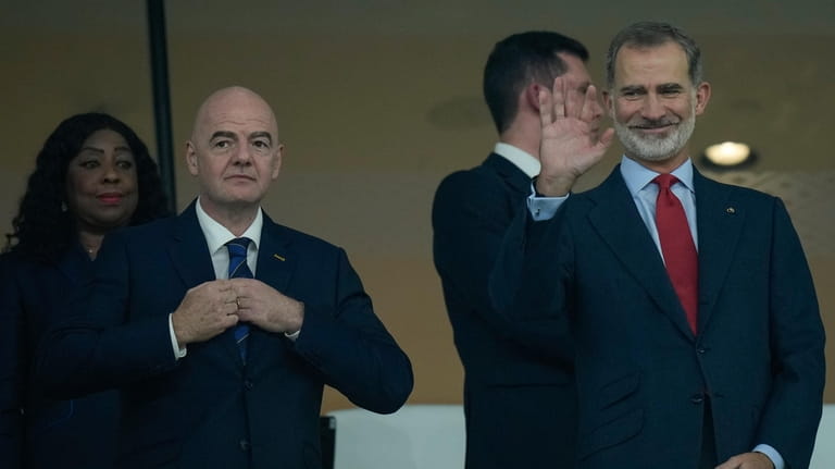 Spain's King Felipe VI, right, waves next to FIFA President...