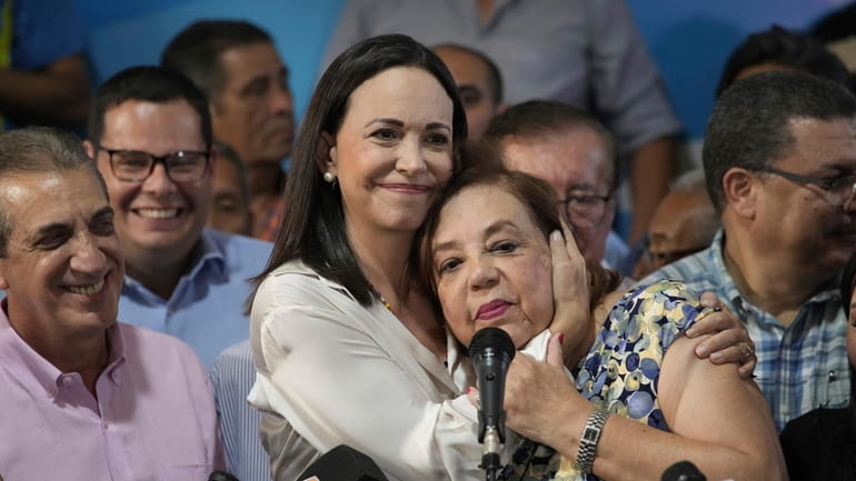 Opposition leader María Corina Machado embraces Corina Yoris during a...