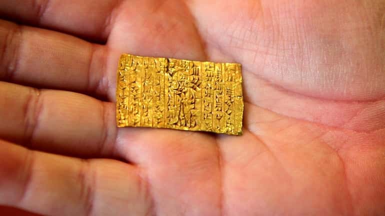 Attorney Steven Schlessinger holds an ancient Assyrian gold Tablet, which...
