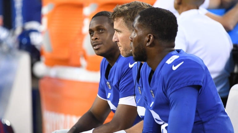 Giants QB Eli Manning, center, sits with backups Geno Smith,...