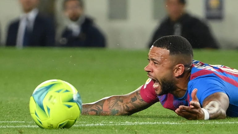 Barcelona's Dutch forward Memphis Depay reacts on the ground during...