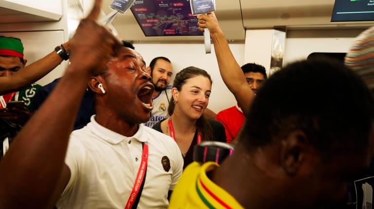 Associated Press correspondent Isabel DeBre, center, smiles as Ghana fans...
