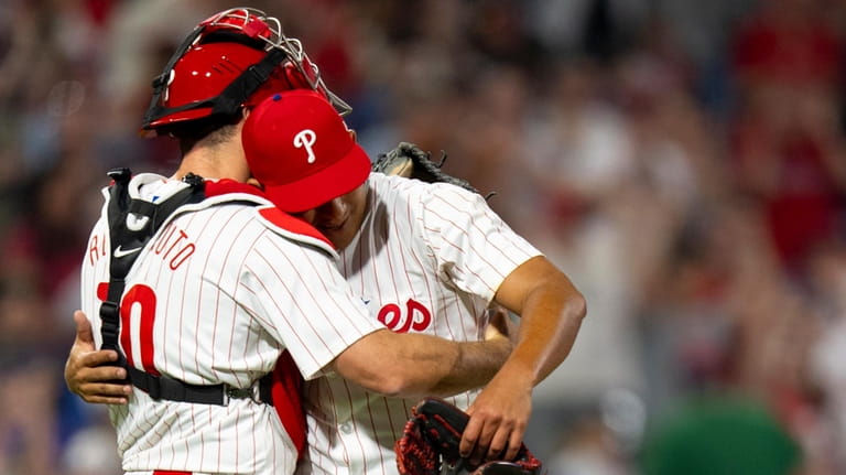 Philadelphia Phillies starting pitcher Ranger Suarez, right, hugs catcher J.T....