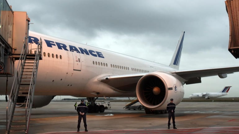 An Air France plane bound for Washington, is guarded by...