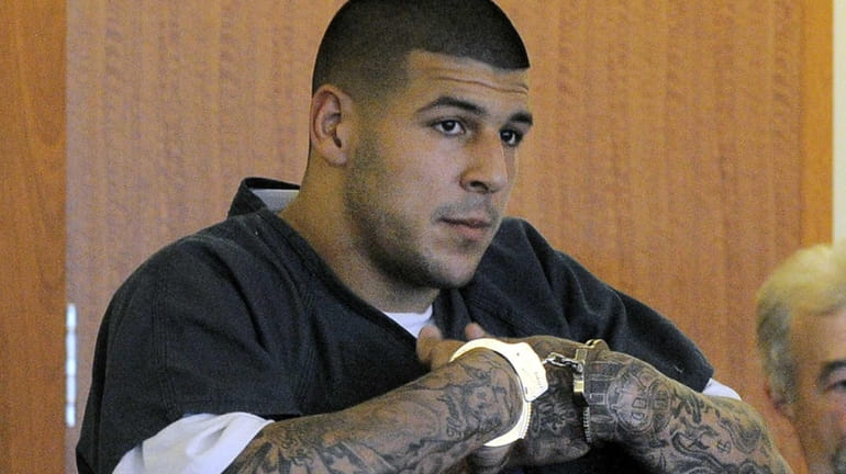Former New England Patriots football tight end Aaron Hernandez stands...