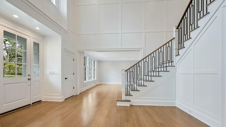 The double-entry foyer has flat-paneled wall detail.