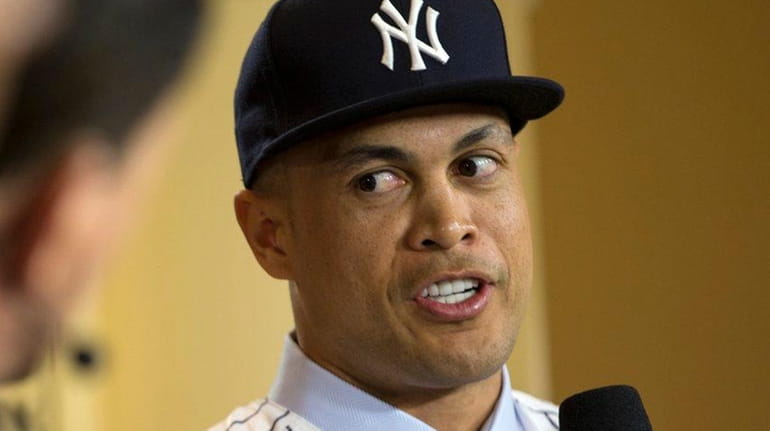 New Yankee Giancarlo Stanton talks with reporters during MLB's winter...