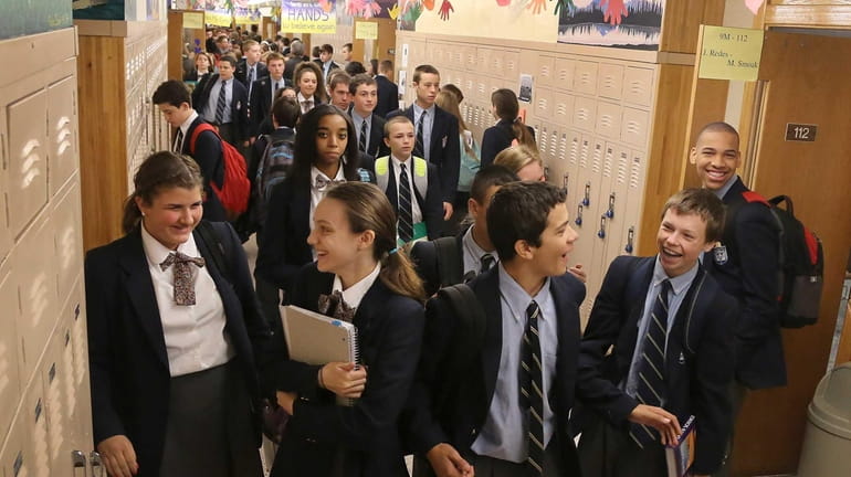 Catholic high school kids walk through the hallway.