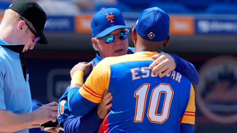 Mets manager Buck Showalter embraces Venezuela's Eduardo Escobar (10) before...