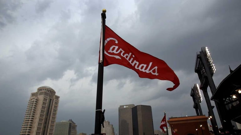 A St. Louis Cardinals banner blows in the wind atop...