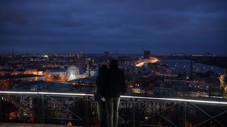 A couple embrace at a viewpoint overlooking Kyiv, Ukraine, Saturday,...
