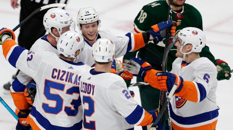 Islanders right wing Tom Kuhnhackl celebrates his goal with teammates...