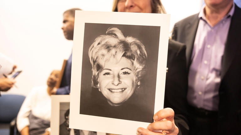 Randi Childs holds a photo of her mother,Sheila Heiman, during a...