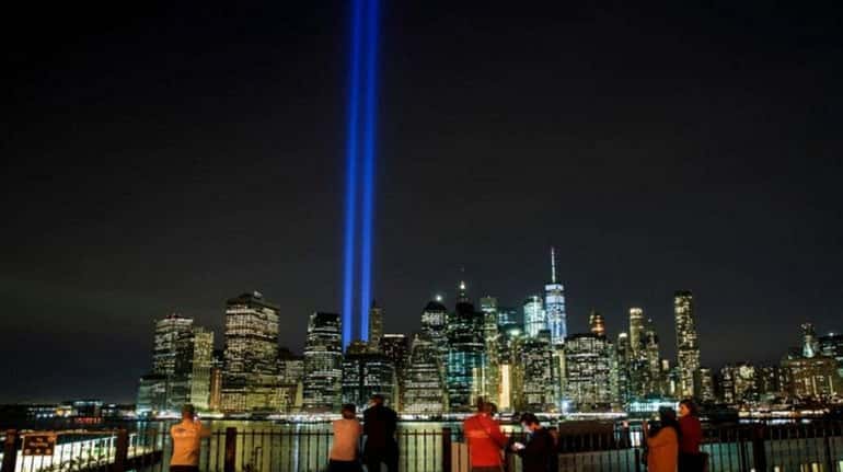 The "Tribute in Light" rises above the skyline of lower...