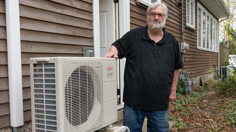 Richard Hucke of Brightwaters shows the heat pump installed at his...