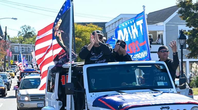 Trump supporters parade in cars and trucks on Main Street...