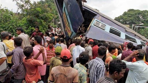 Local residents gather at the site of a train accident...