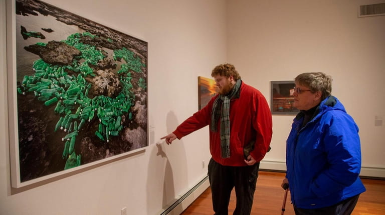 Susan and Christopher Heilig, of Jericho, explore an art exhibit on...
