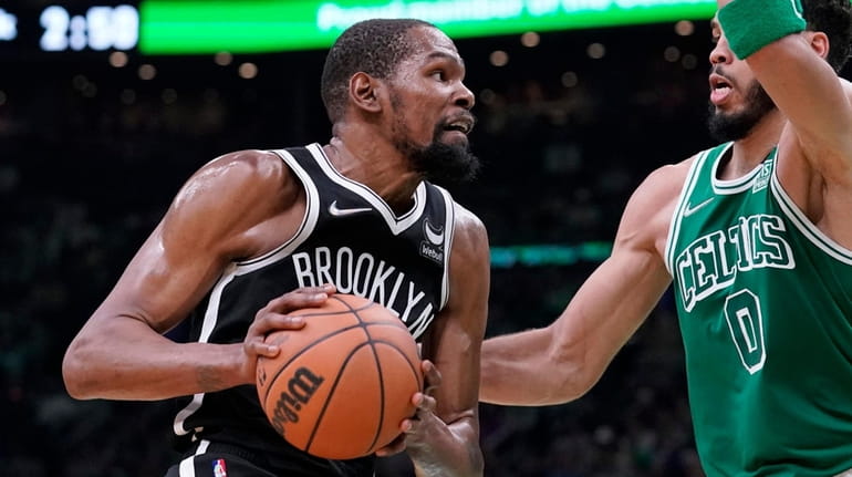 Brooklyn Nets forward Kevin Durant, left, drives toward the basket...
