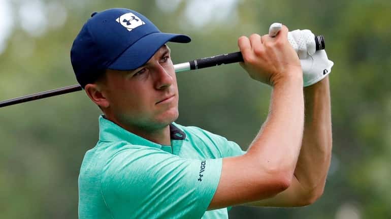 Jordan Spieth watches his tee shot on the 15th hole...