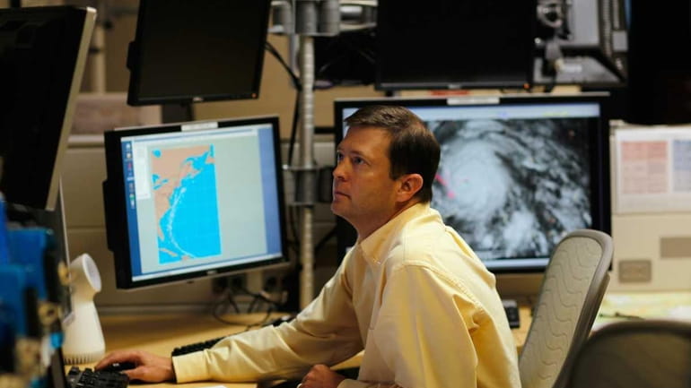 Senior Hurricane Specialist Daniel Brown studies computer models as he...