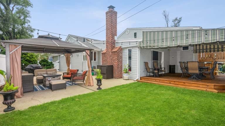 The backyard has an awning-covered patio and a pergola.