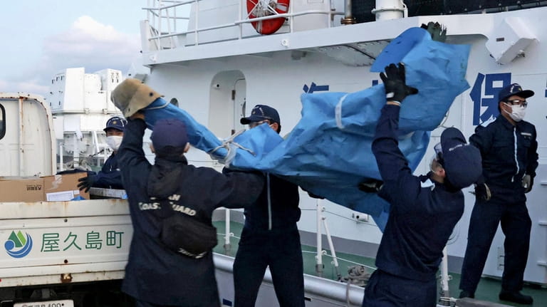 The members of Japanese Coast Guard carry the debris which...