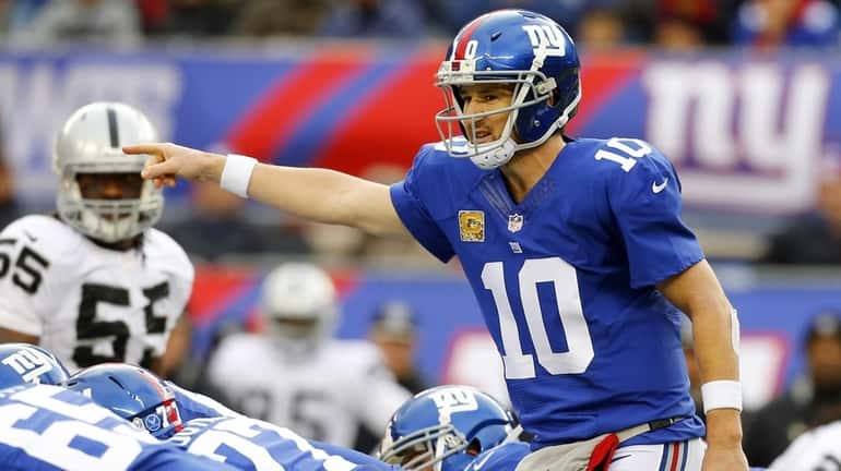 Giants quarterback Eli Manning (no. 10) directs his team against...