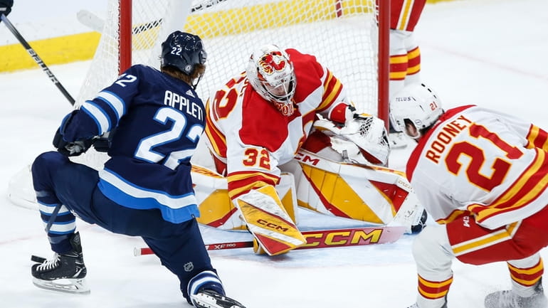Calgary Flames goaltender Dustin Wolf (32) makes a save against...